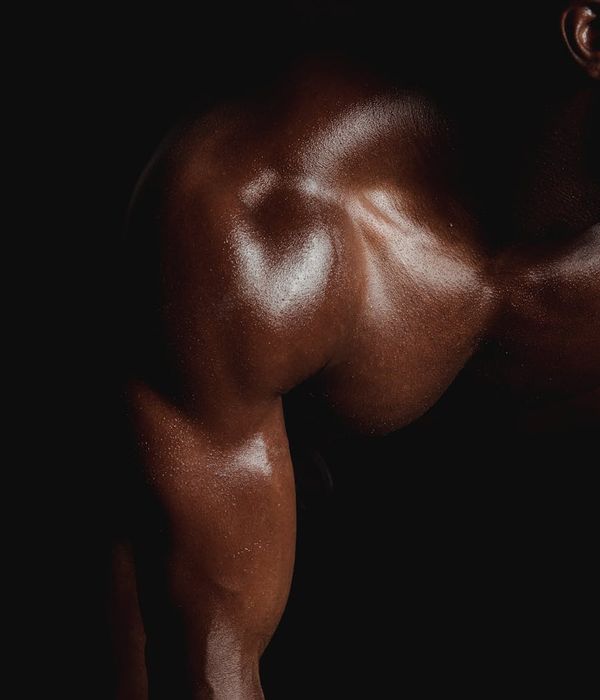Man performing a controlled strength exercise in a dark gym environment.